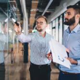 two men looking at whiteboard